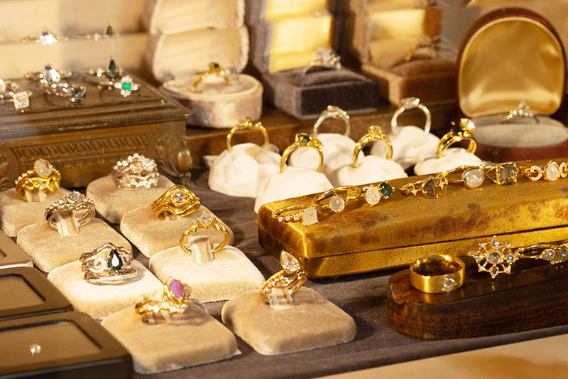 Display case with one-of-a-kind engagement rings under warm lighting